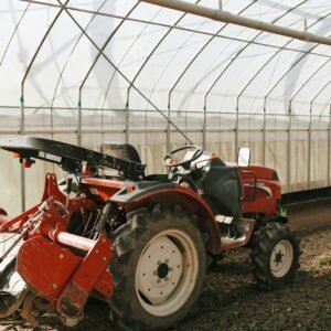 a red tractor is parked in a greenhouse